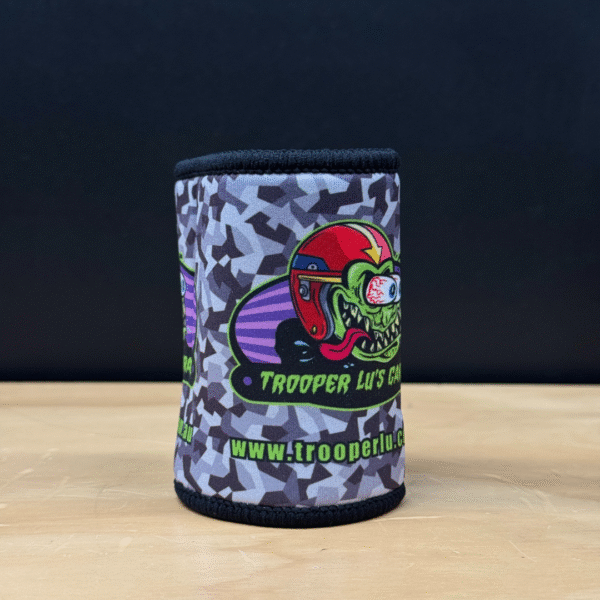The TROOPER LU'S GARAGE STUBBY COOLER features camouflage, a cartoon lizard in a red helmet, "Trooper Lu's Garage" text, and the website www.trooperlu.com.au.