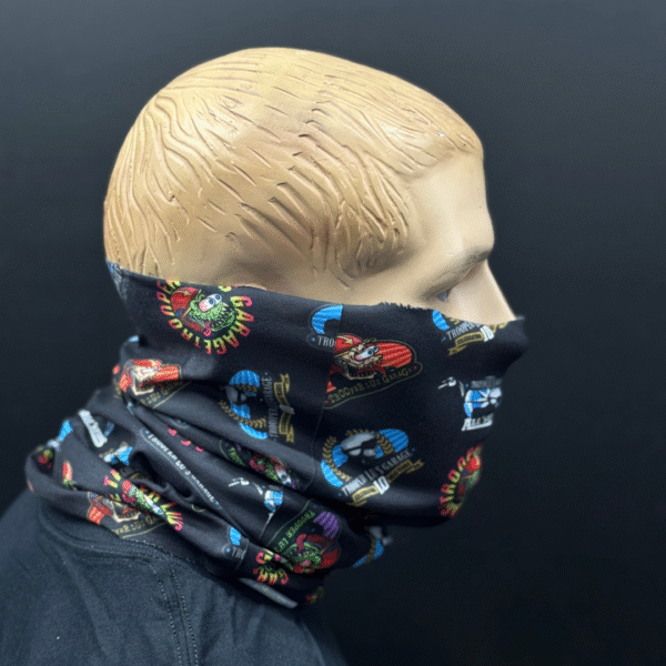 A mannequin head displays the HEADSKINZ TROOPER LU'S NECKWARMER, a black neck gaiter with colorful cartoon designs, covering its nose, mouth, and neck against a plain dark background.
