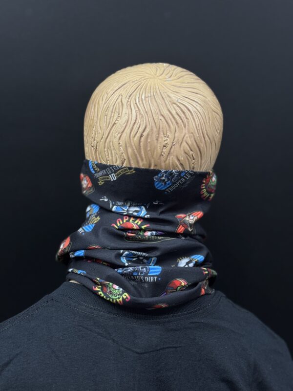 A mannequin head with a textured surface displays the HEADSKINZ TROOPER LU'S NECKWARMER, a black neck gaiter featuring colorful car-themed graphics, shown from the back against a plain black background.