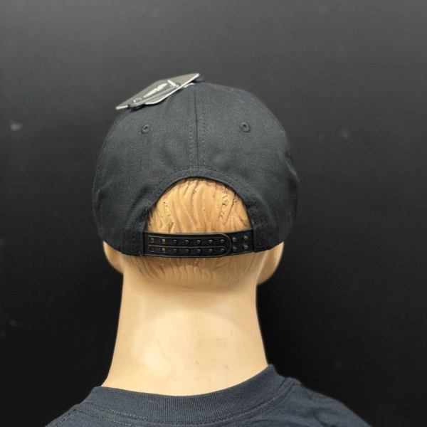 A mannequin head displays TLG's UFLEX PRO STYLE SNAPBACK CAP BLACK from the back, showing a clothing tag attached to the top of the adjustable black cap.