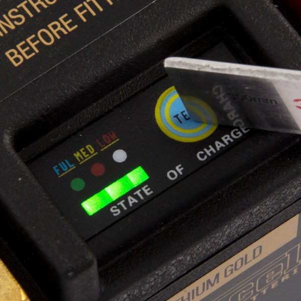 A close-up of the MOTOCELL LITHIUM GOLD MLG7L battery charge indicator shows "State of Charge" with full green bars, and a knife blade is inserted above the display.