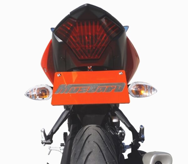 Rear view of YZF-R3 2019 ONWARDS MUSTARD TAIL TIDY - 186mm, featuring an orange license plate, clear tail light, and turn signals on each side against a white background.